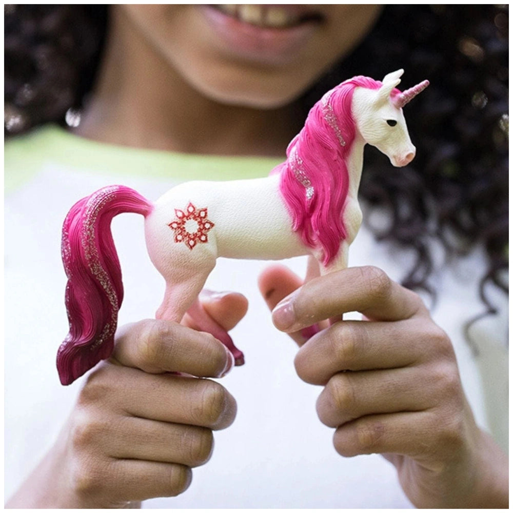 Mandala Unicorn Sea figurine with white body and pink accents, held by a young adult in an indoor setting.