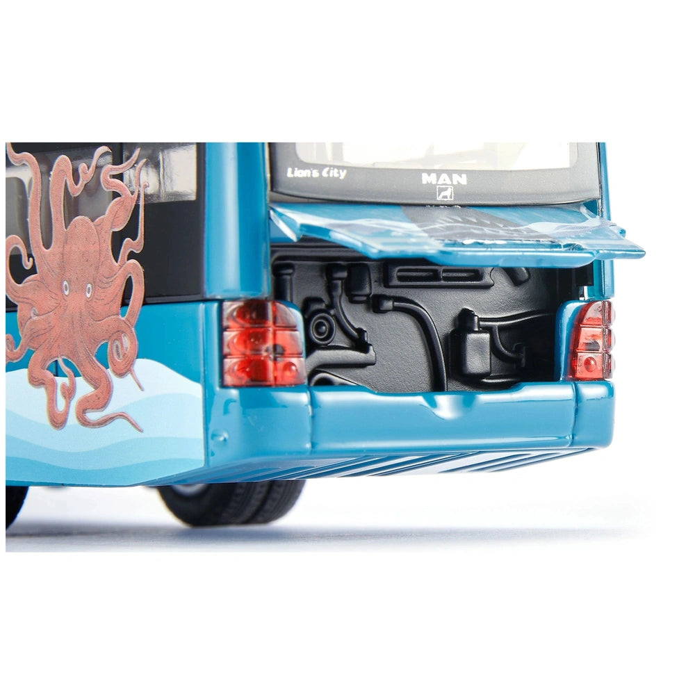 Articulated bus features a blue body panel, black spare tire cover, and a clear plastic cover over the spare tire compartment