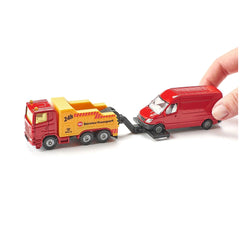 Siku breakdown truck in yellow with red stripes loads a small red toy car held by a hand on a flat surface.