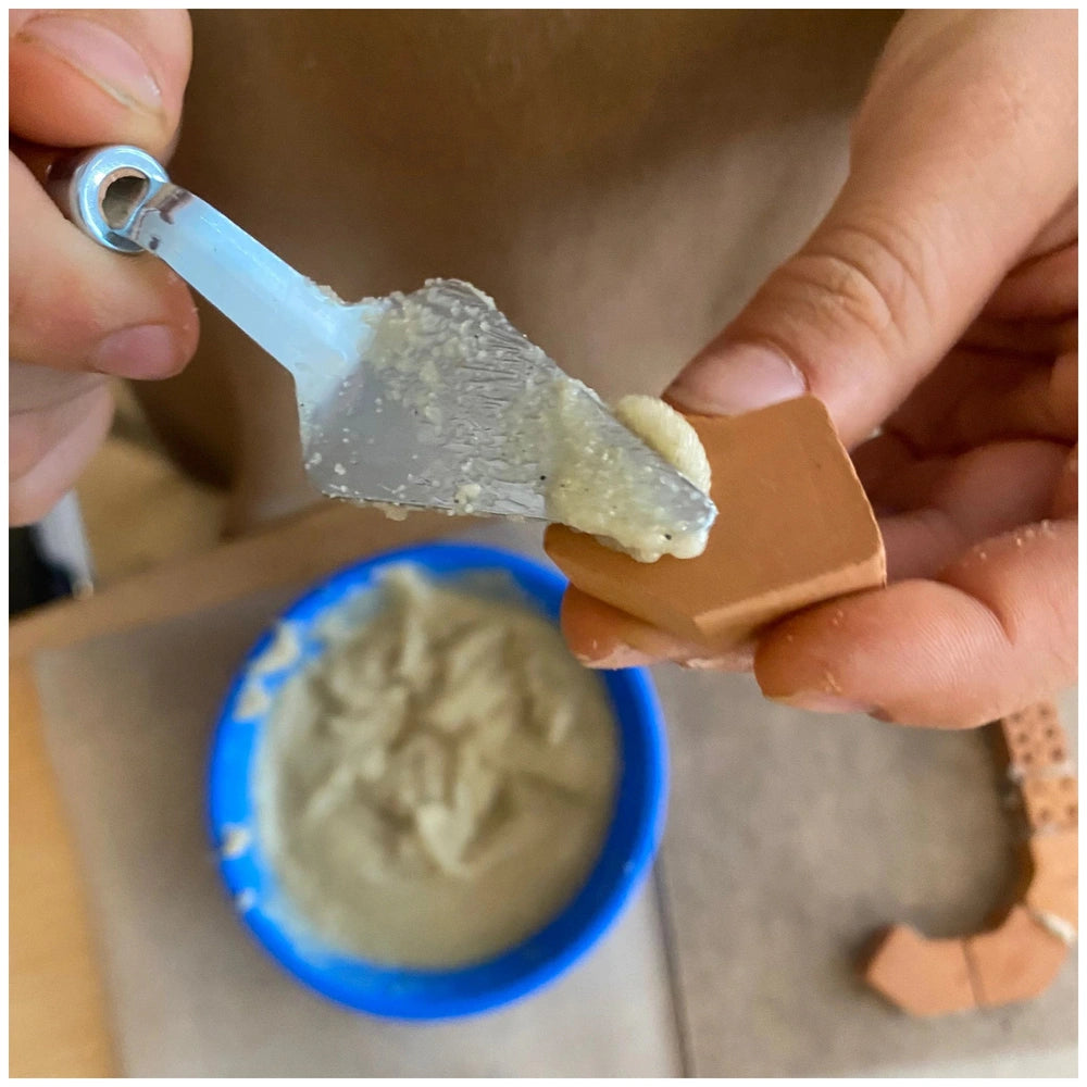 Teifoc Church arts and crafts kit includes hands holding a clear spoon scooping creamy substance from a blue bowl.