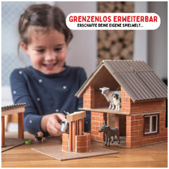 Teifoc arts and crafts set featuring a smiling girl with a model house, showcasing a sheep and dog figurines on the roof.