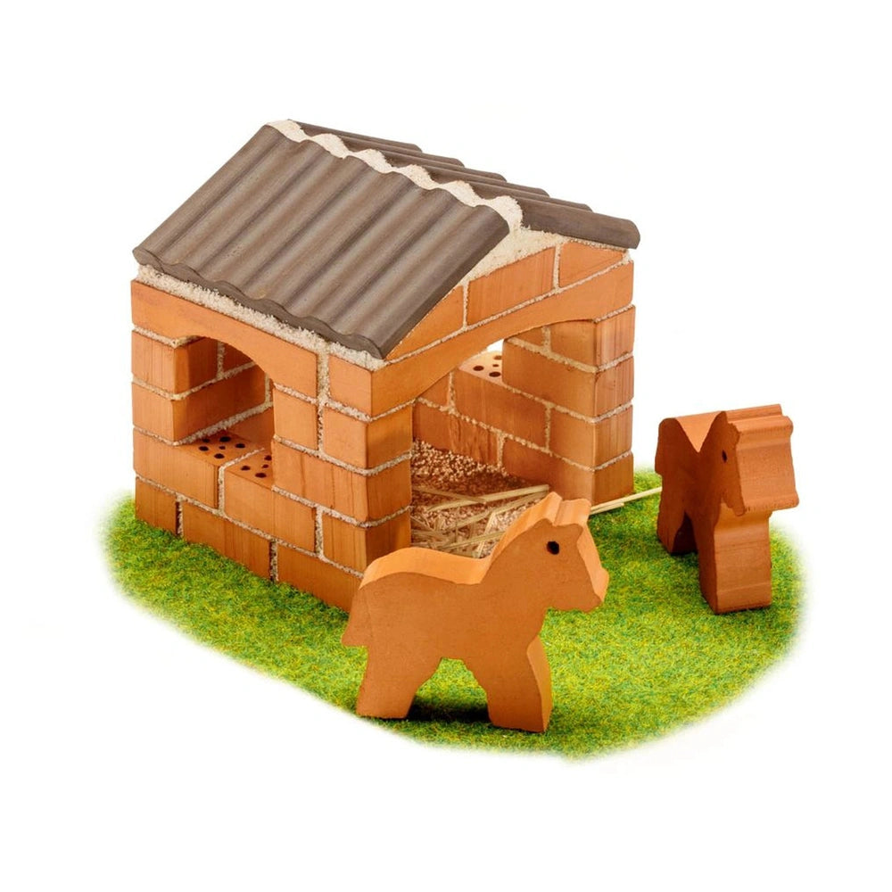 Teifoc little horse stable features a brown model house with a sloping roof on a green grass-like surface and a horse figure.