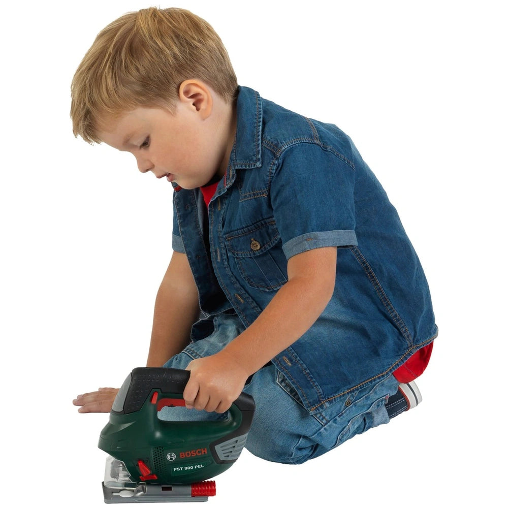 Theo Klein Bosch jigsaw toy held by a child in blue denim, featuring multiple red switches and a clear window for pretend pla