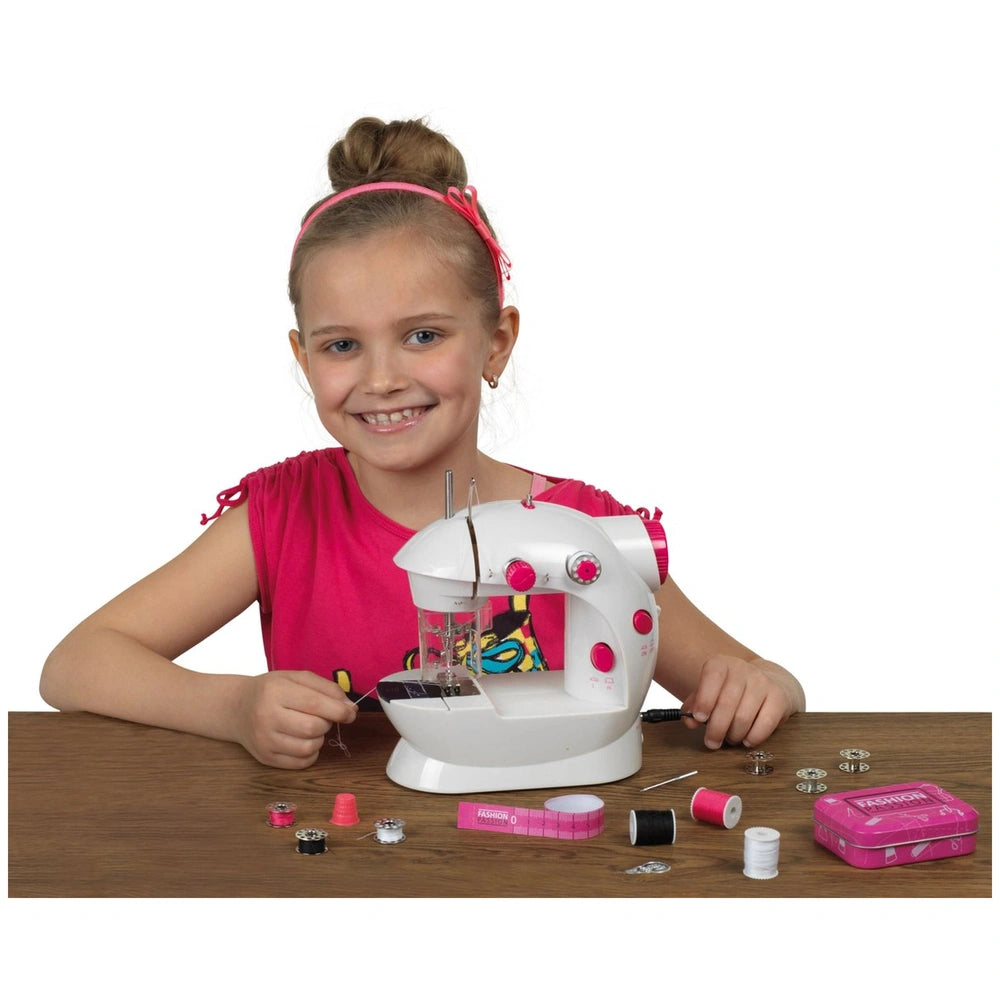 Kids sewing machine in white with pink accents held by a girl in a pink top, surrounded by colorful spools and needles on a w