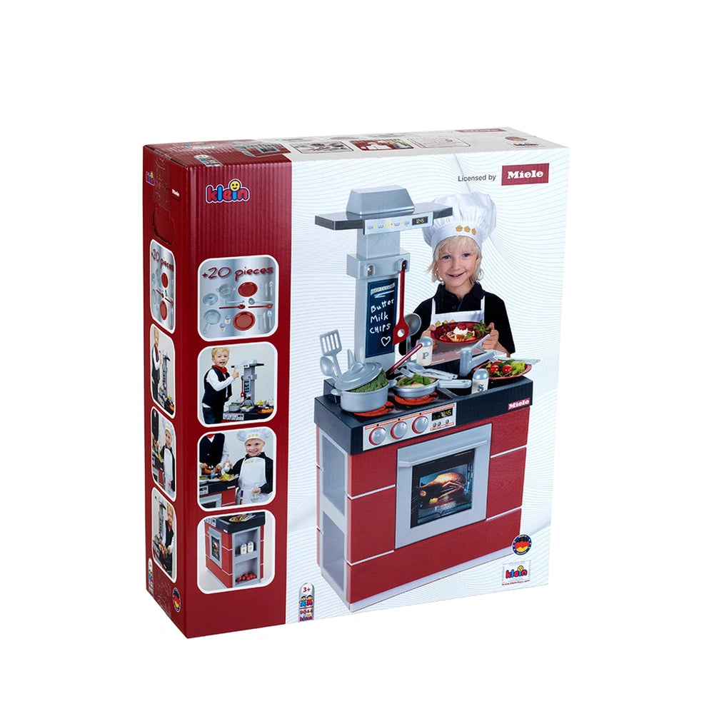 Theo Klein Miele kitchen compact set with child in chef's hat holding food, glossy packaging, red and white toy kitchen.
